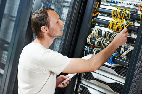 Technicus werkt aan een patchpaneel in een serverkast